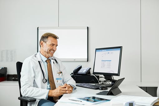 A young man conducts a video conference consultation with a doctor online sitting at home.