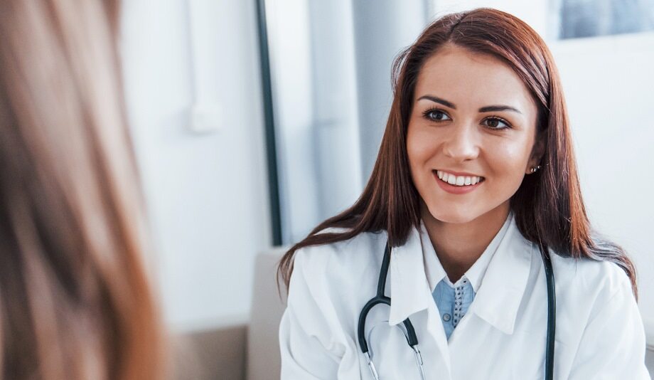 A smiling woman doctor examining a patient.